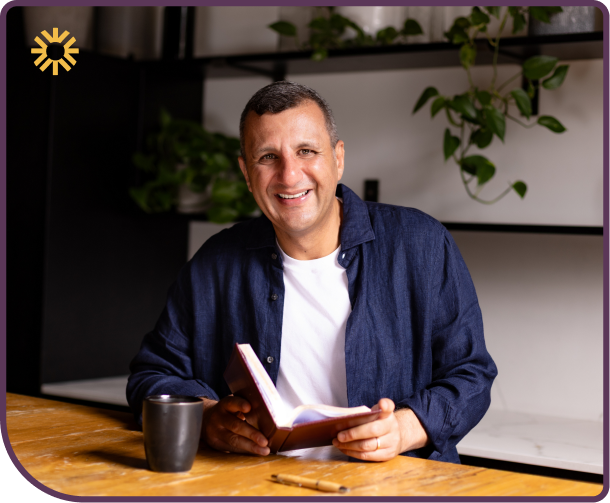 Raf Massih holding a notebook in his coaching studio